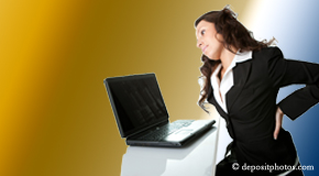 a person New York City bending over a computer holding her back due to pain